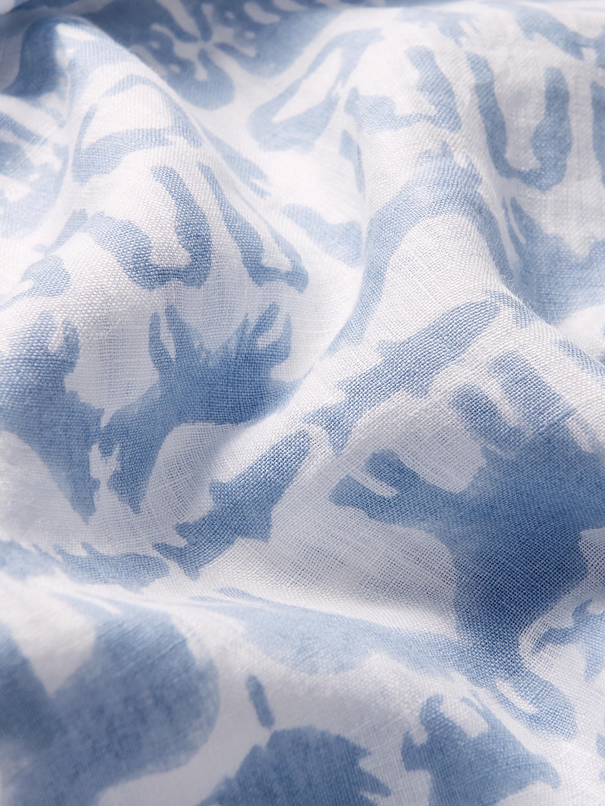 Close-up view of sky blue animal print on the Unisex Eleuthera linen Trousers made from 100% premium Belgian linen.