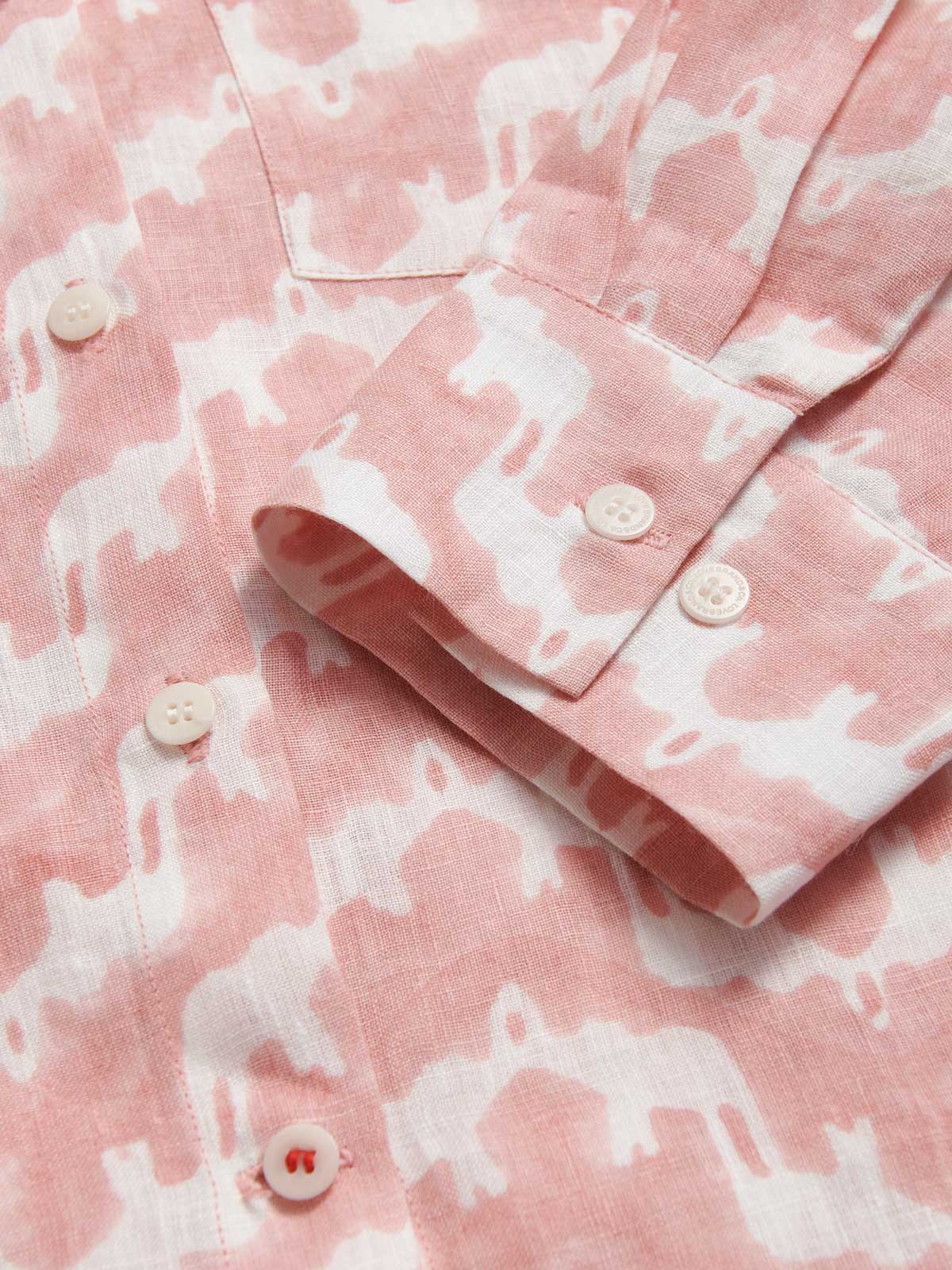Close-up view of our pink and white elephant palace print on our womens linen shirts. Close-up of our corozo nut button cuffs.