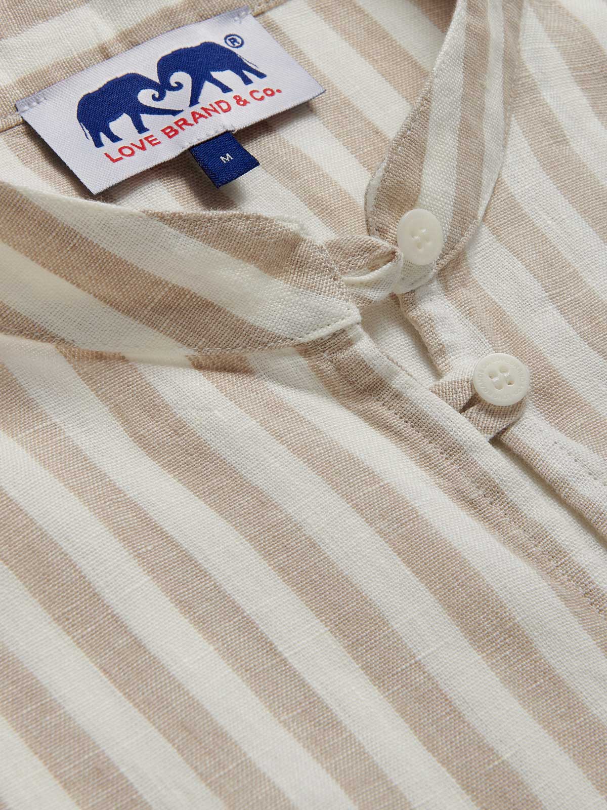 Womens Coconut Stripe Jumento Linen Poncho close-up collar view. Beige and white striped pattern on short sleeved, half-button up shirt dress poncho.