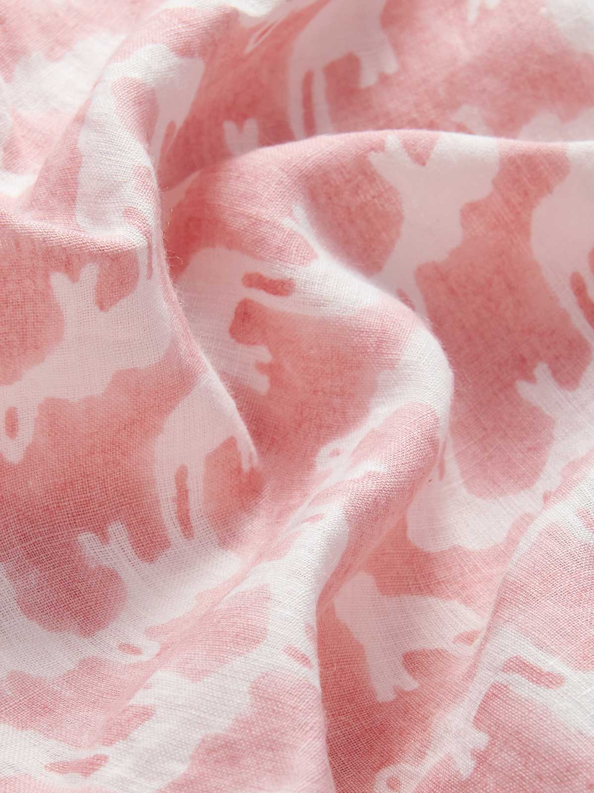 Deatiled view of Womens Elephant Palace Strawberry Musha Linen Shorts. Close-up of pink and white elephant print made from 100% linen hand block-printed by Indian artisans.