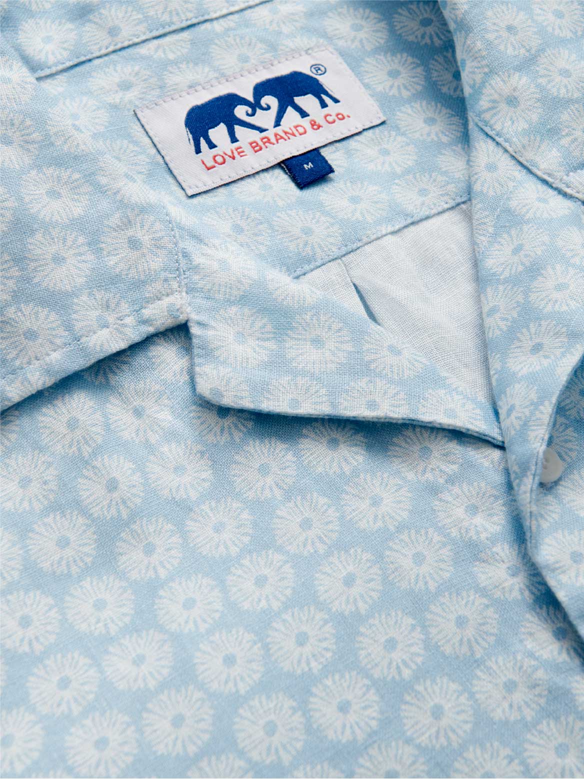 Light blue shirt with white floral pattern and Love Brand & Co. tag.