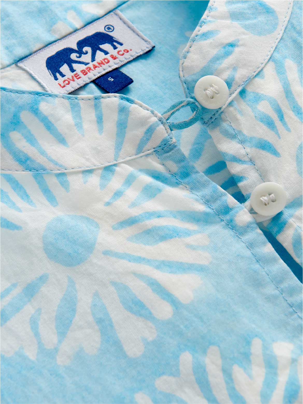 Close-up of a blue and white beach poncho with a love brand label.