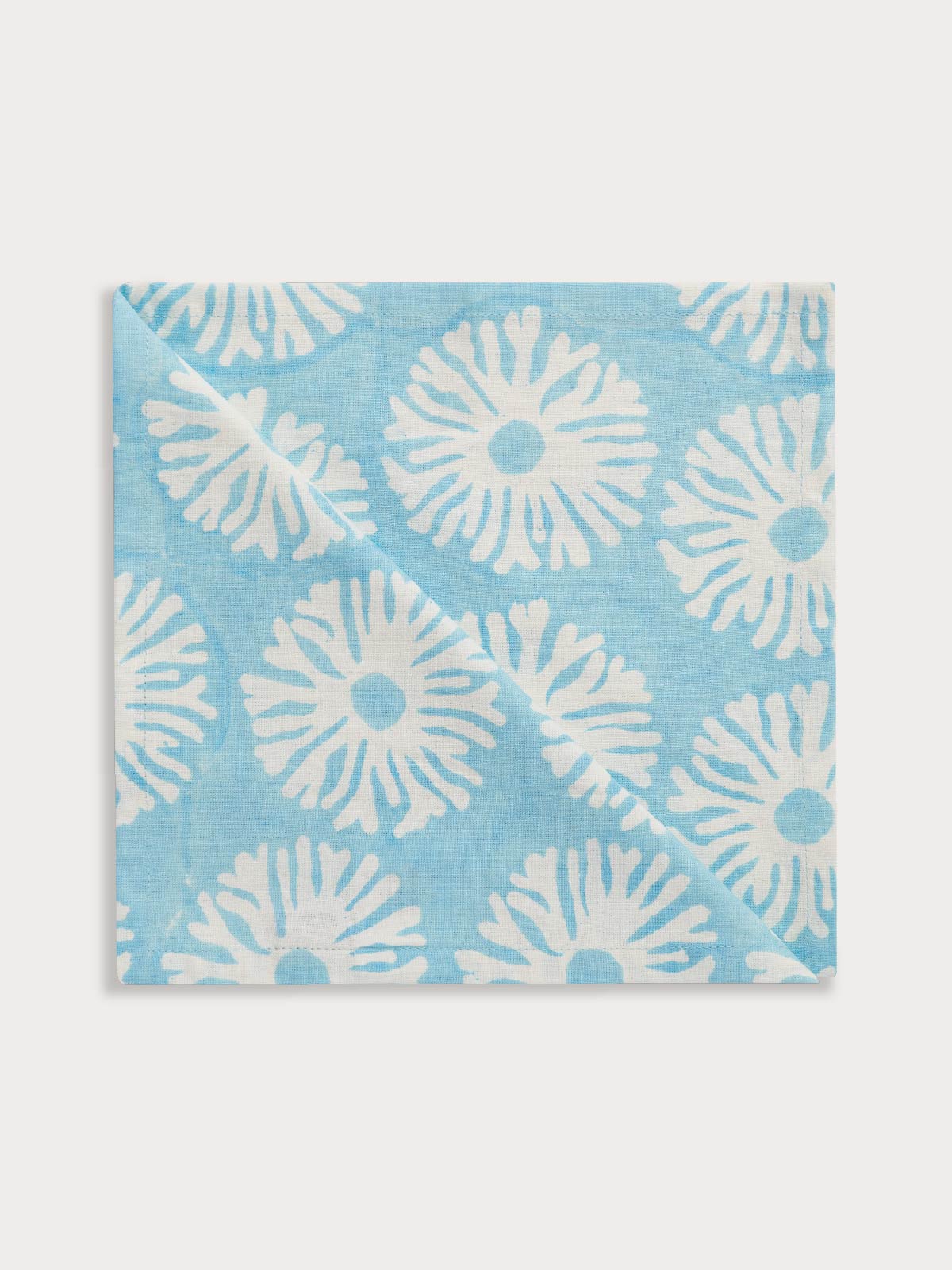 Blue cotton napkins with coral reef design on a white background.