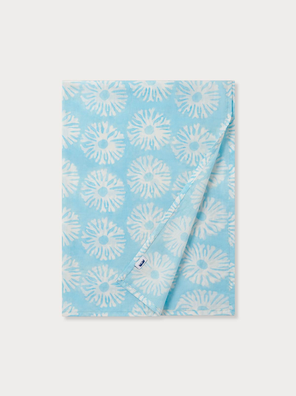 view of a blue cotton scarf folded on a flat white background