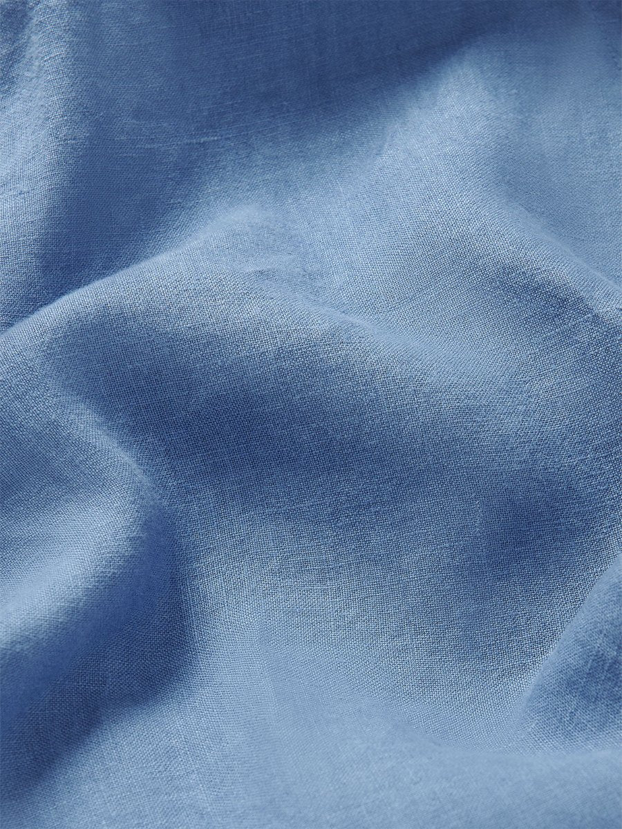 Close-up view of the luxurious blue linen fabric used in Love Brand blue linen trousers mens. Close-up of blue drawstring trouser showcasing its fine texture and quality.