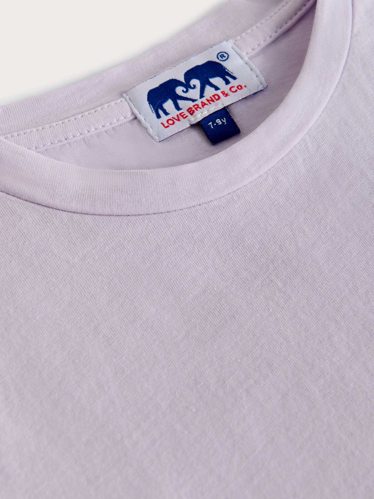 Close-up of a kids purple t-shirt on a white background.