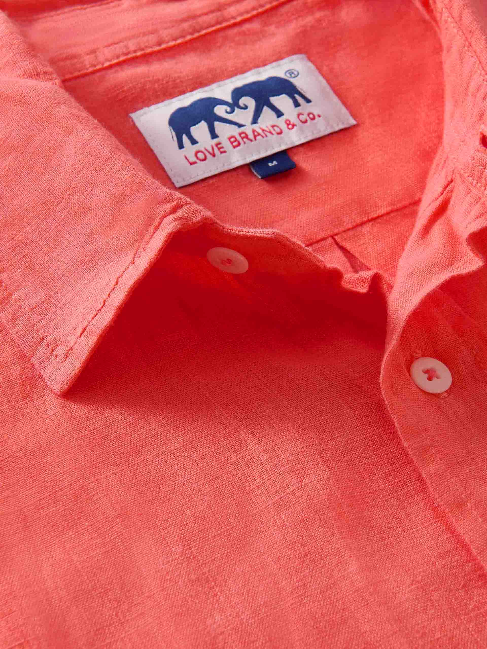 Close-up of a coral-colored shirt with a visible brand label.