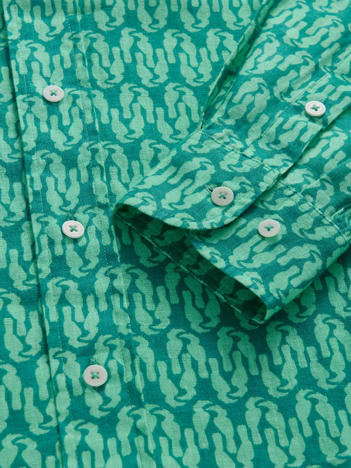 Close-up of a green patterned shirt with buttons.