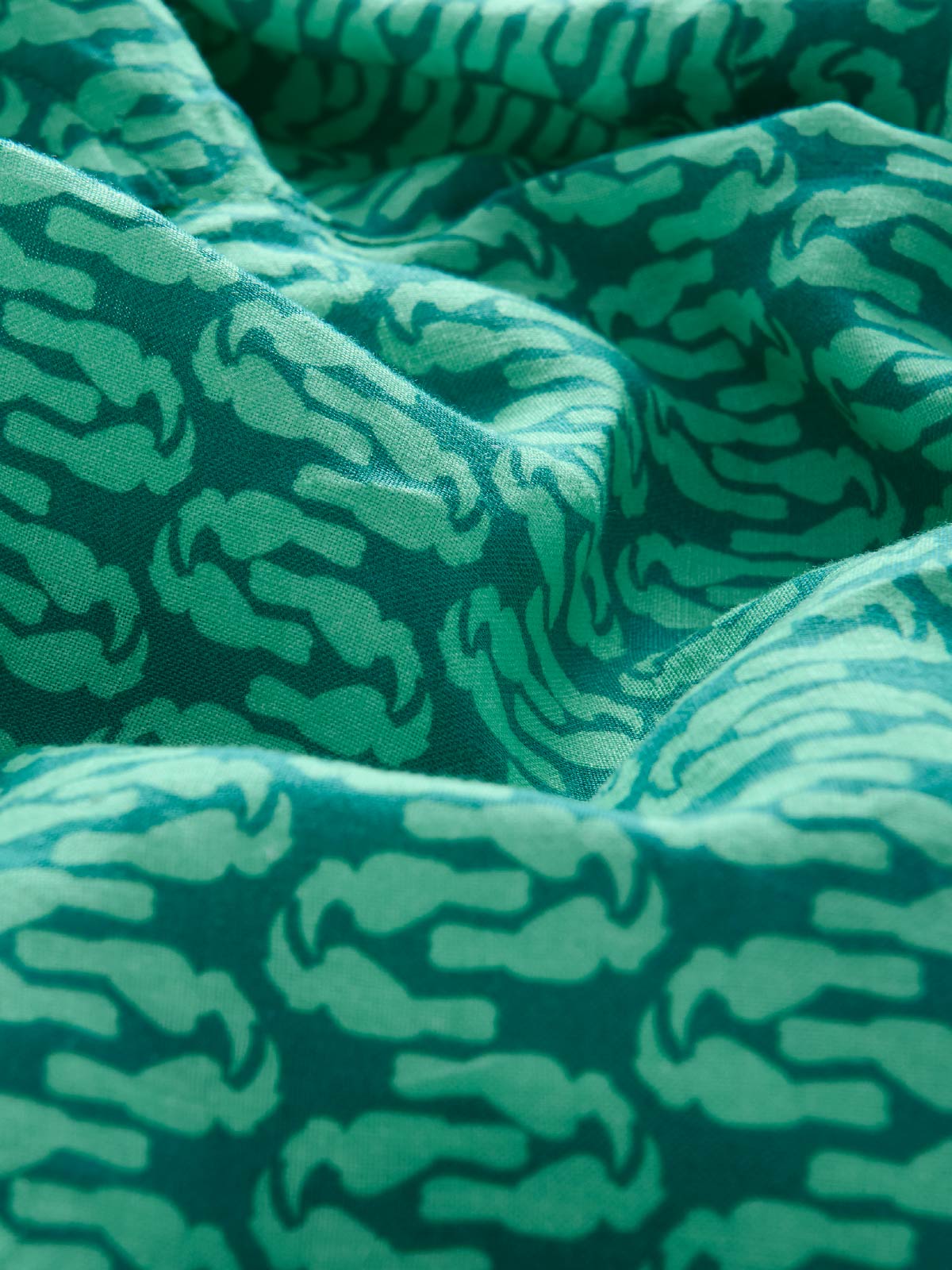 Close-up of green linen fabric with animal pattern