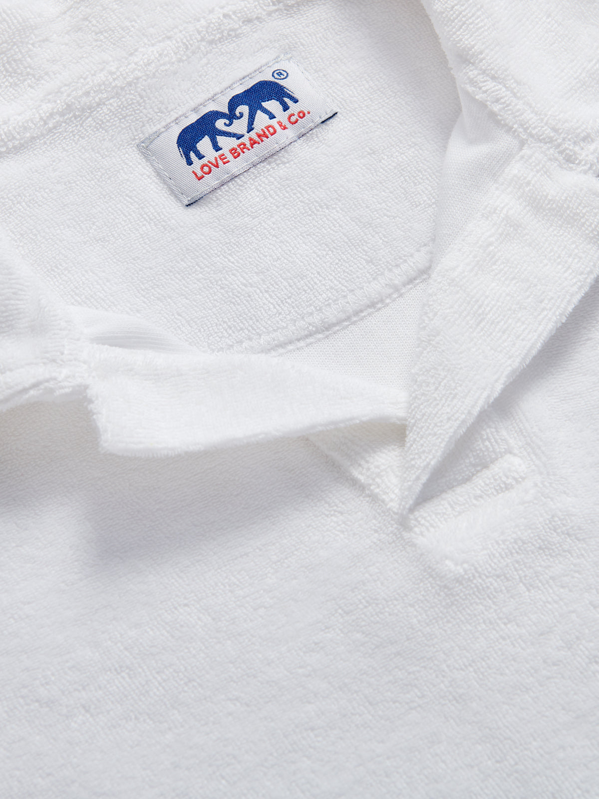 Detailed view of Kids White Powell Terry Polo Shirt made from 100% cotton.