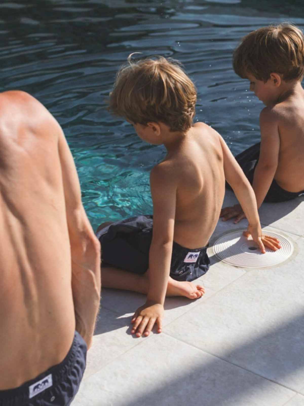 family wear luxury swimwear brands uk while sitting by the pool.