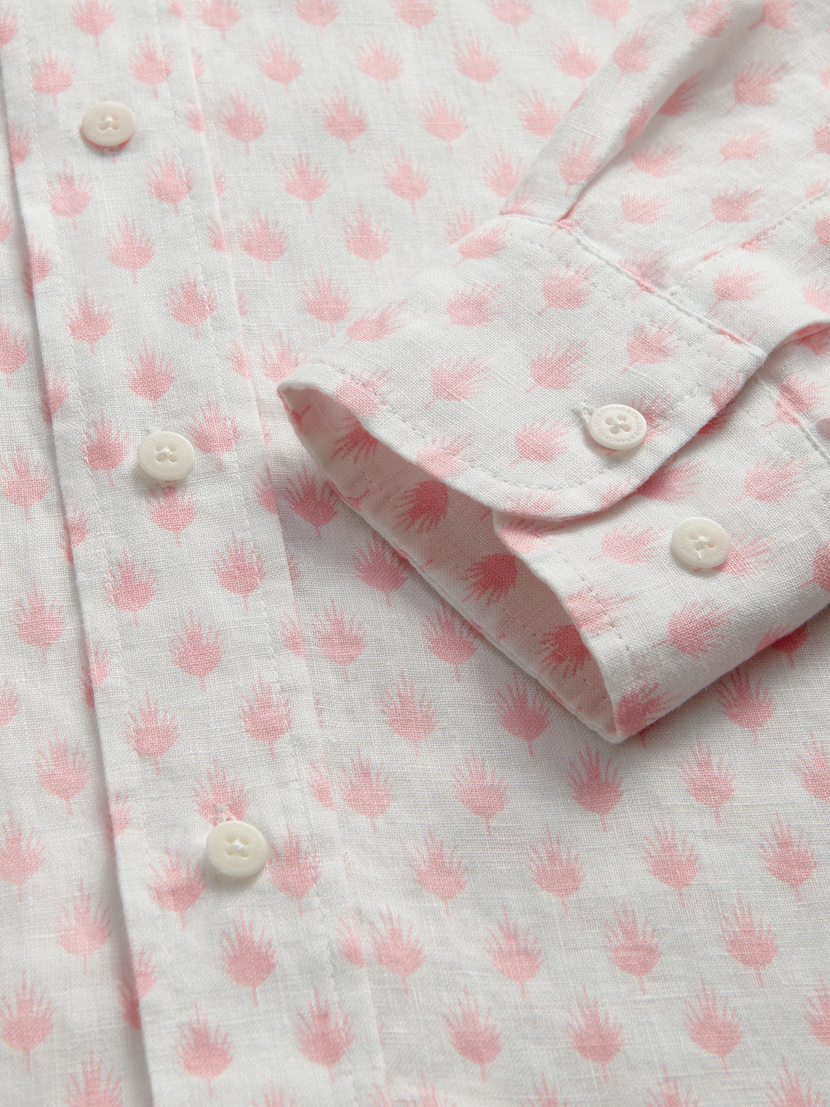 Close-up of a pink and white patterned shirt with buttons.