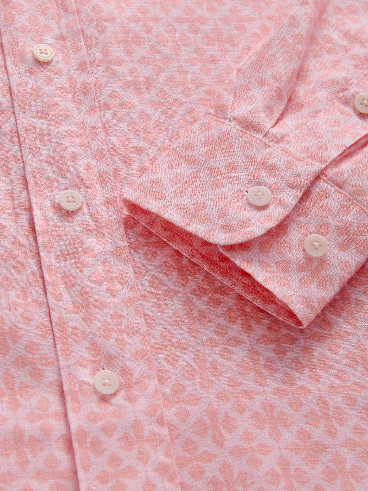 Close-up of a pink patterned shirt with buttons.