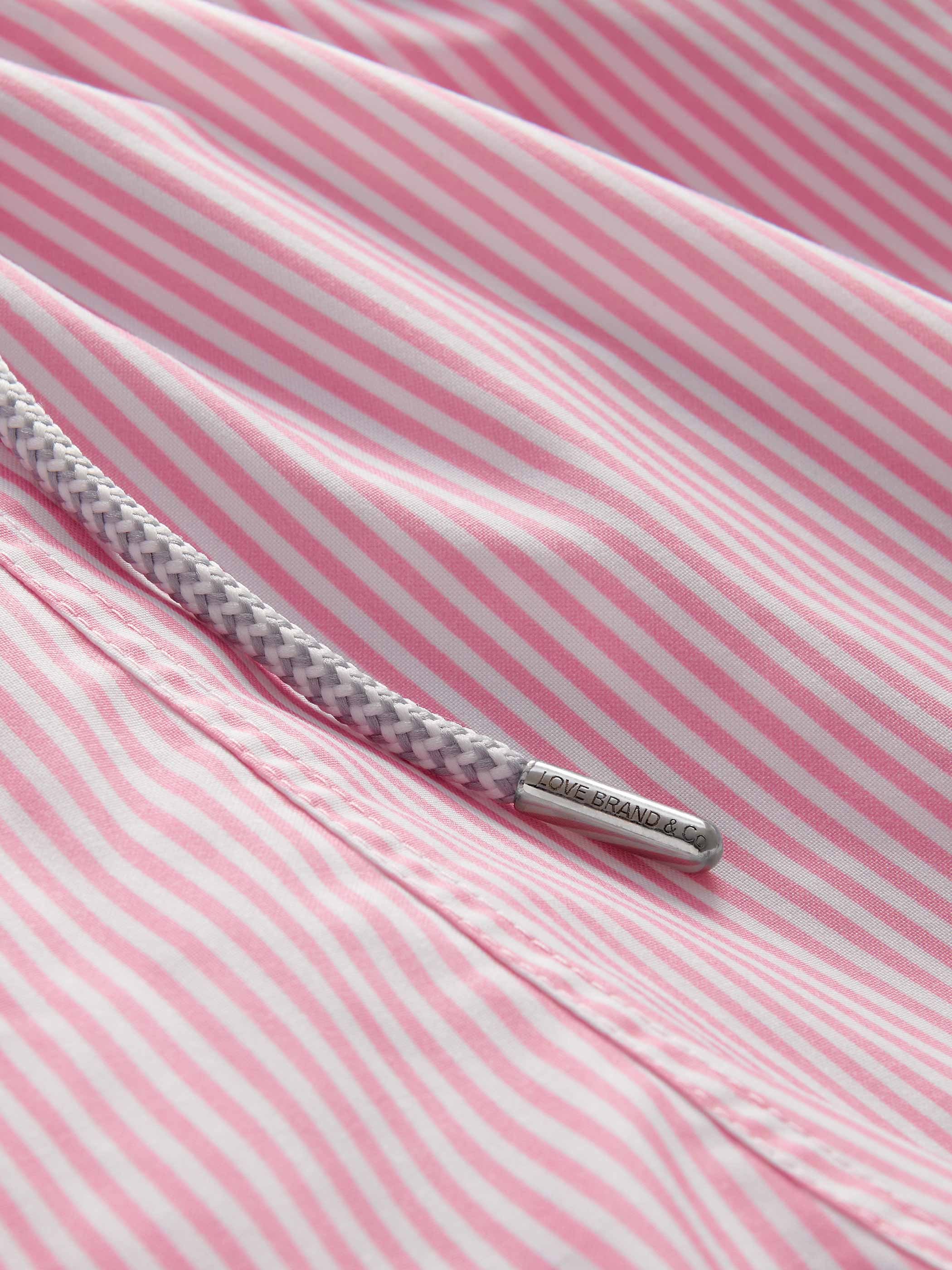 Close-up of pink and white striped fabric with a metal drawstring.
