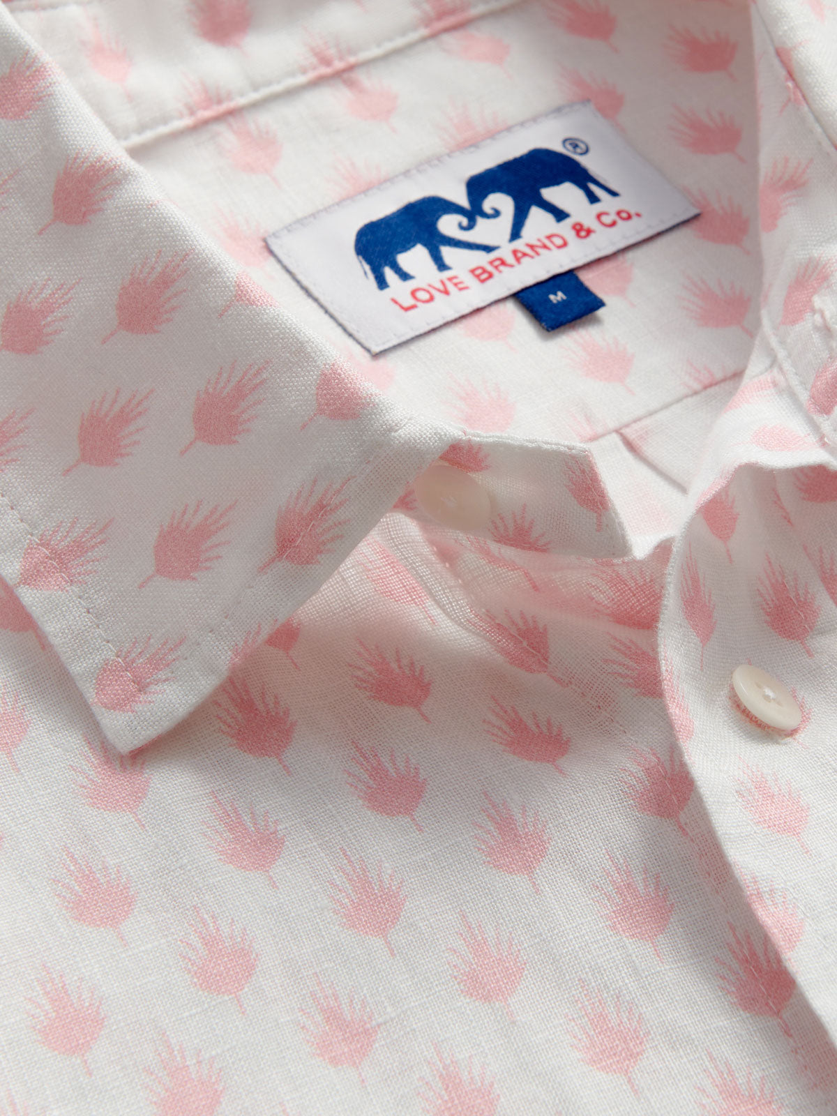Close-up of a shirt with pink pattern and Love Brand & Co. label.