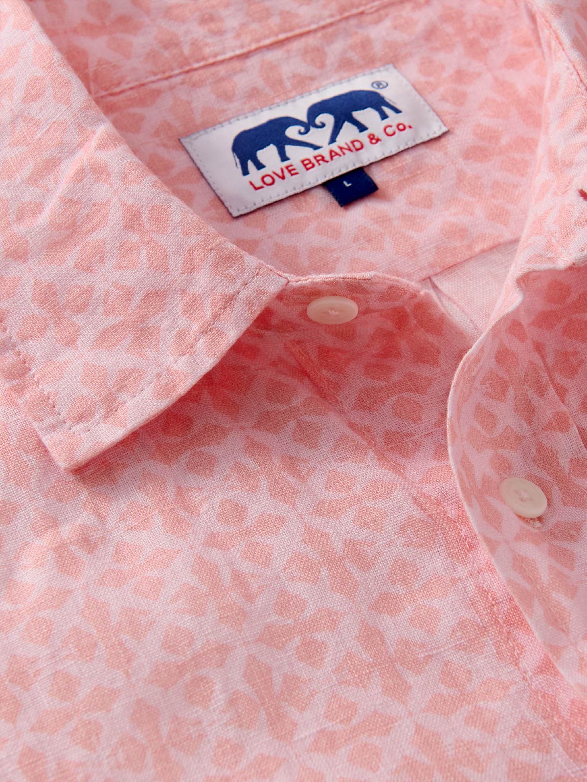 Close-up of a pink patterned shirt with a visible love brand label.