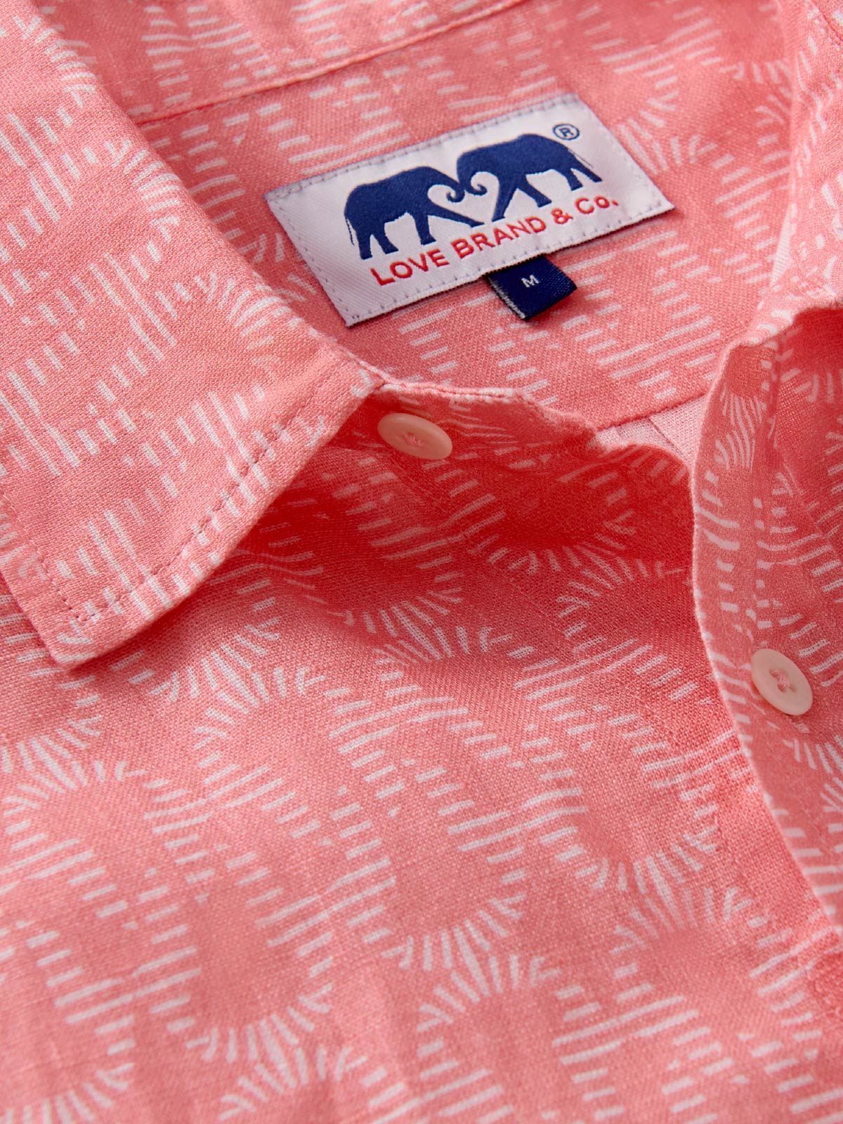 Close-up of a pink shirt with a visible love brand label.