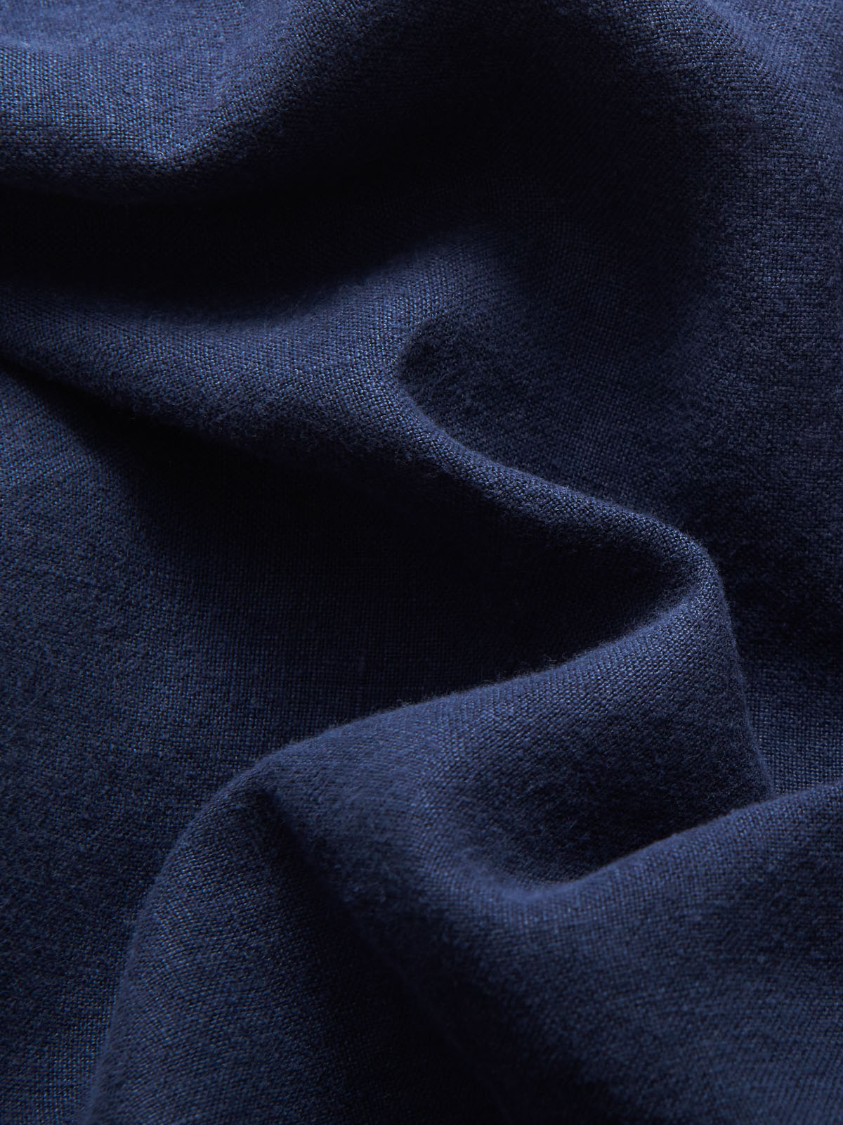 Detailed view of 100% organic linen fabric of mens navy blue linen shorts.