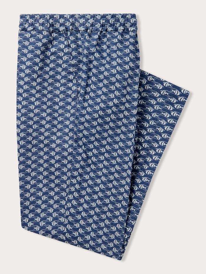 Men's Go with the Flow Eleuthera Linen Trousers. Mens linen clothing featuring a print of Moorish Idol fish on a deep blue base. Side view image of the folded drawstring trouser.