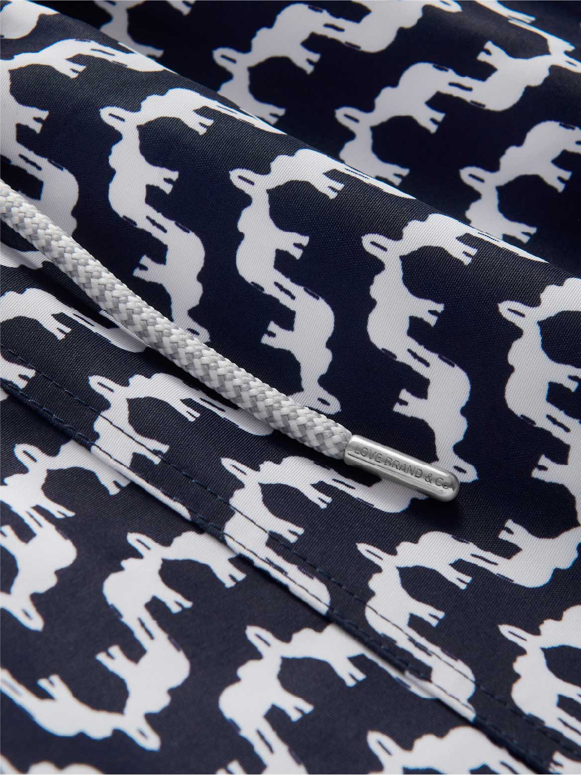Navy blue swimming shorts fabric with white elephant pattern.