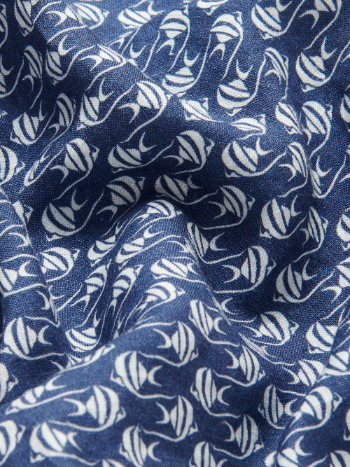 Close-up view of the deep blue linen fabric of the Men's Go with the Flow Eleuthera Linen Trousers. Navy blue linen trousers featuring an elegant Moorish Idol fish print with flowing wave patterns.