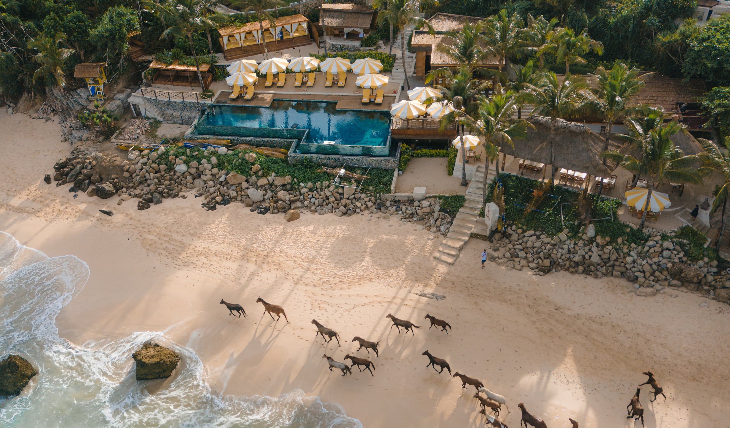 Aerial view of the luxurious beachfront resort of Nihi Sumba with a pool and ocean view.