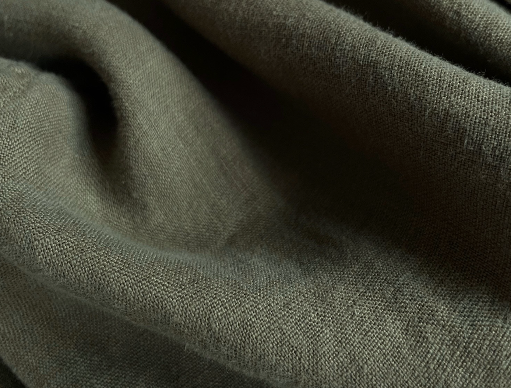 Men's Olive Green Randall Linen Trousers fabric close-up showing rich texture.