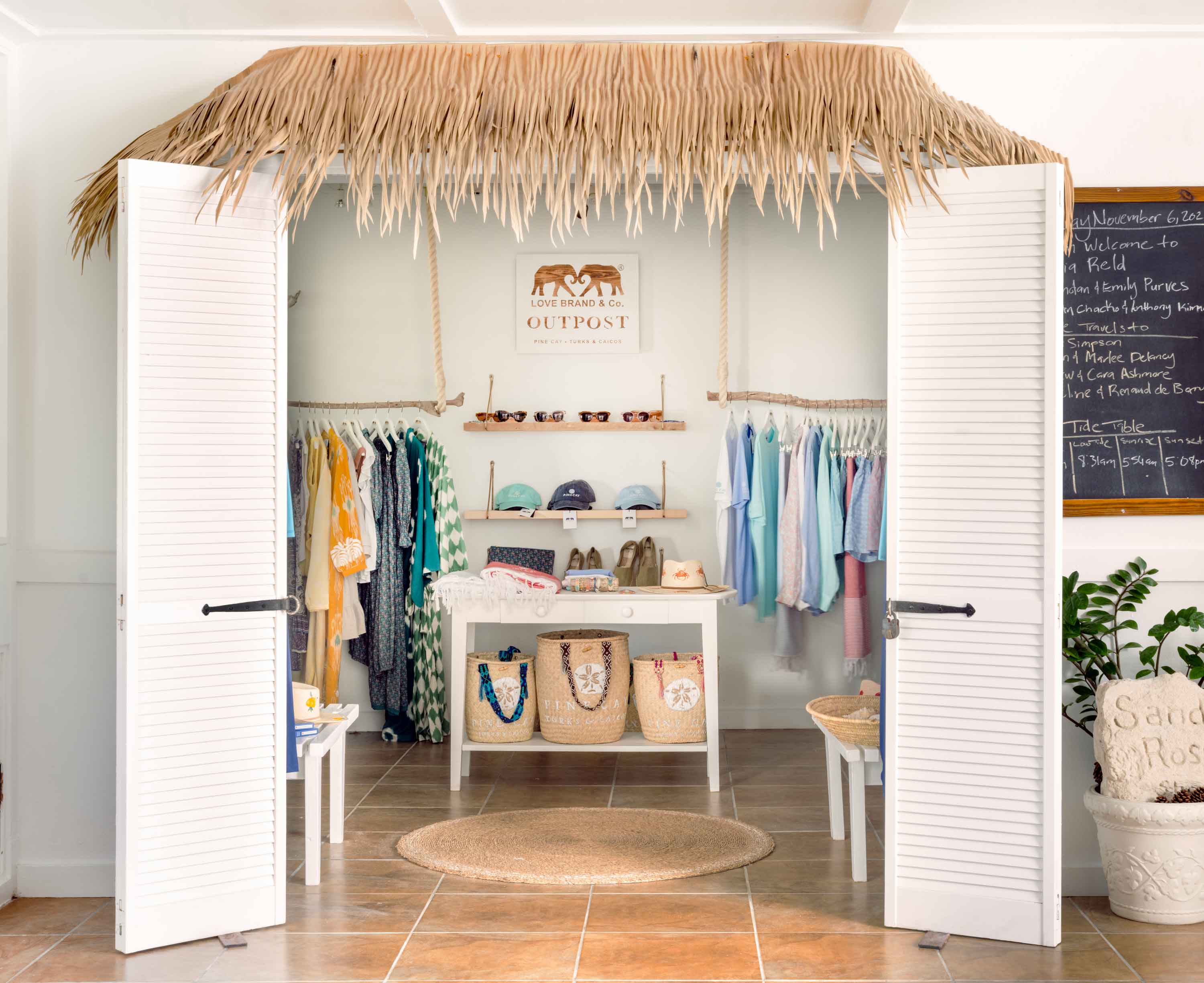 Store interior with clothing racks and a thatched roof design.