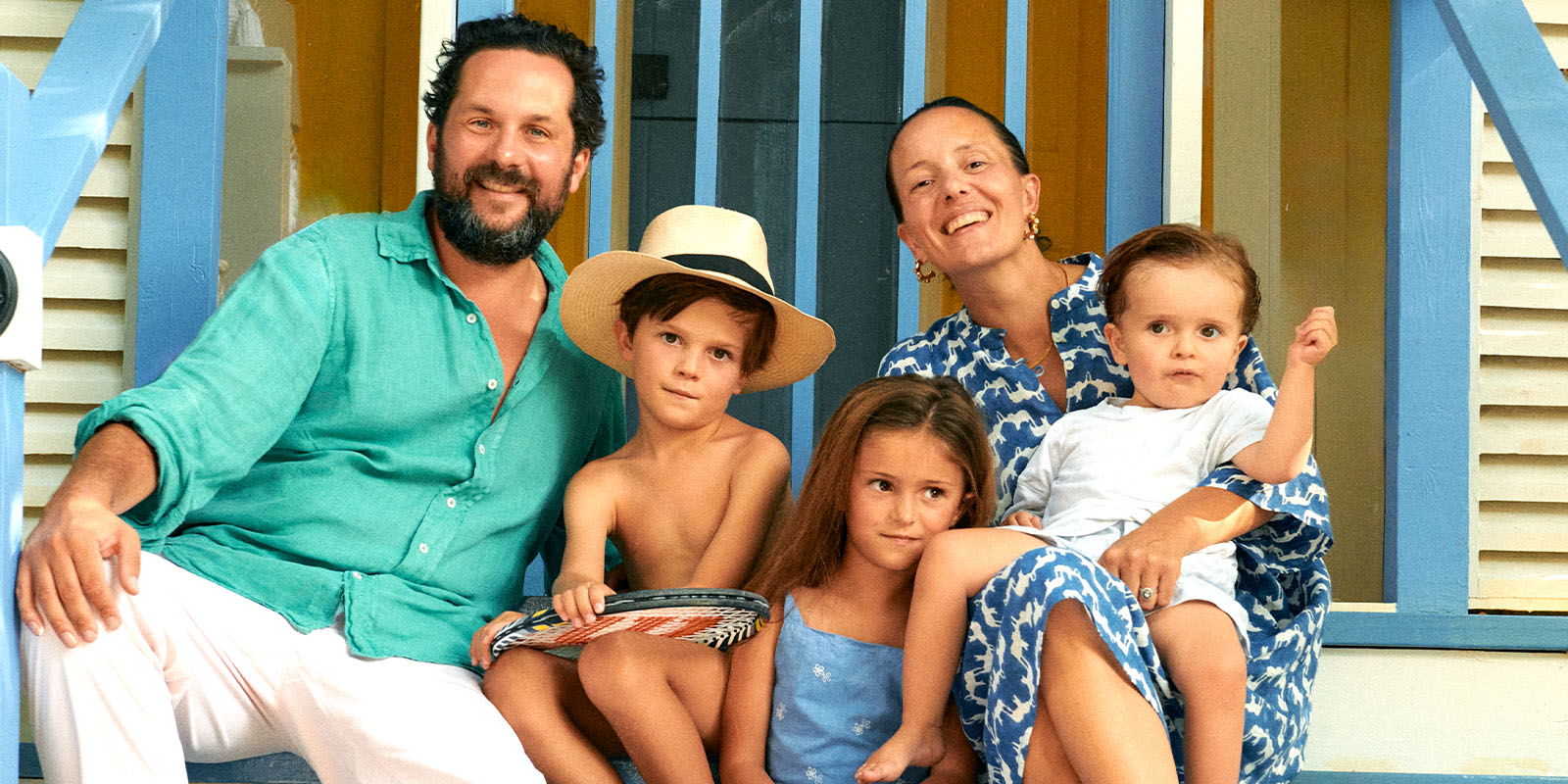 swimming shorts designer Oliver Tomalin with family on a beach house wearing their resort wear uk.