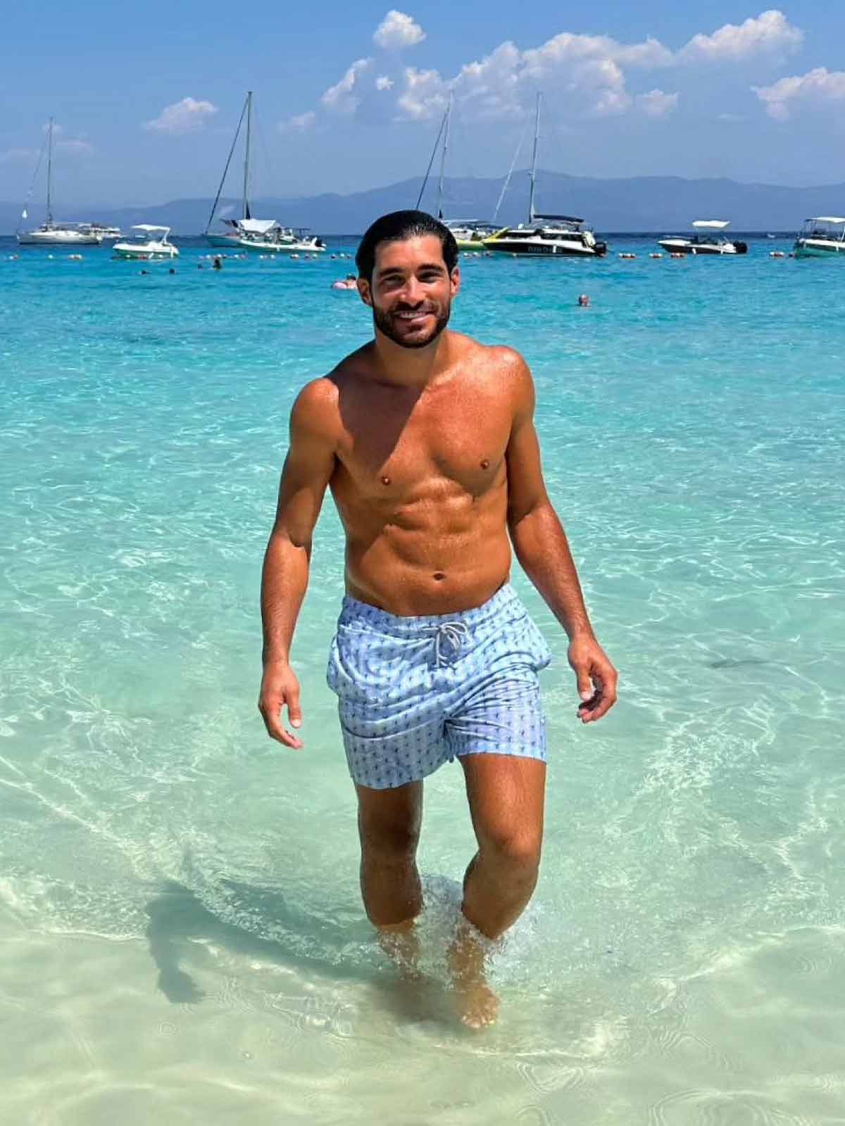man wears blue swim shorts from luxury beachwear brand uk love brand & co.