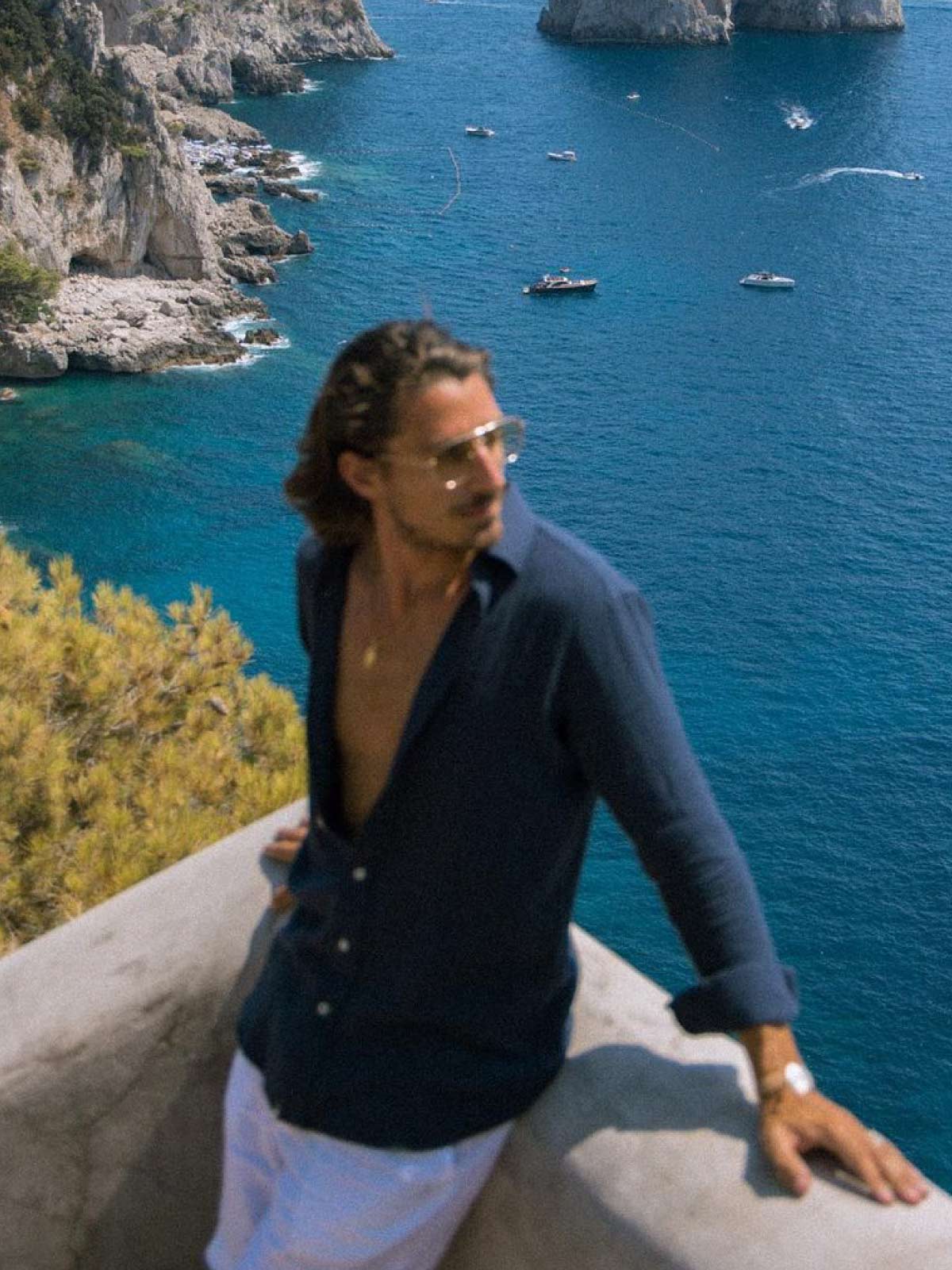 man wearing beach clothing brands looking out onto the ocean on holiday