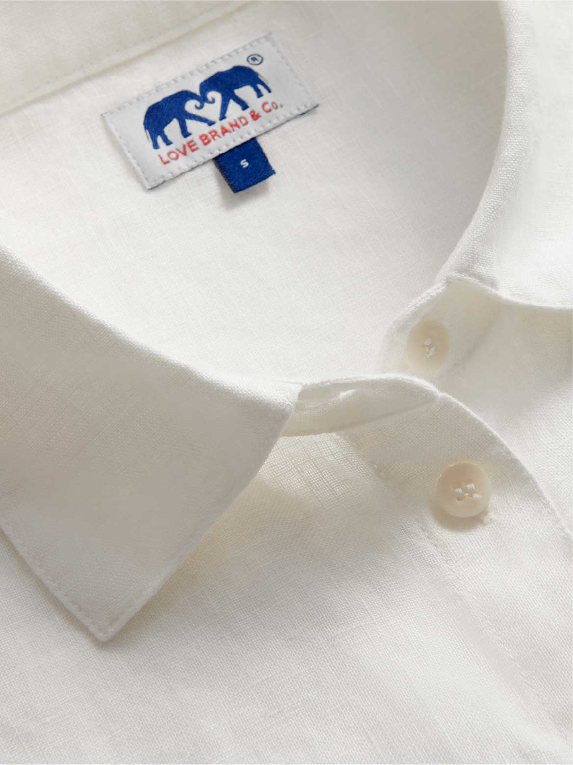 Close-up of a white shirt dress collar with a visible love brand label.