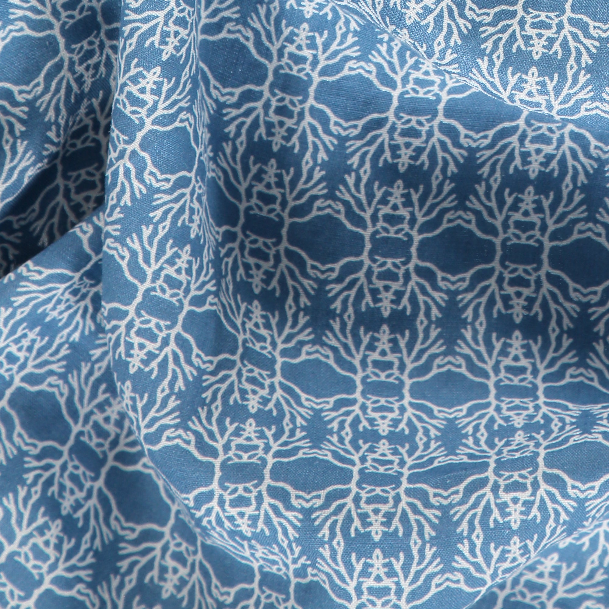 Close-up of the Men's Constant Coral Abaco Linen Shirt featuring a finely drawn white coral motif on a sun-beaten blue background.