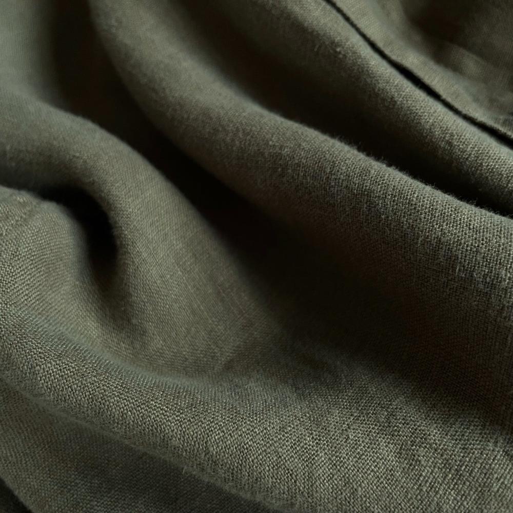 Close-up view of the fabric texture of the Men's Olive Green Abaco Linen Shirt. Close-up of olive green linen shirts highlighting the high-quality 100% natural linen material.