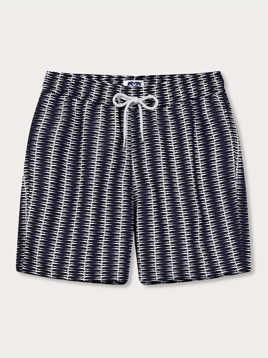 A pair of men's swim shorts with a geometric pattern featuring sardine motifs in a navy and white color scheme.