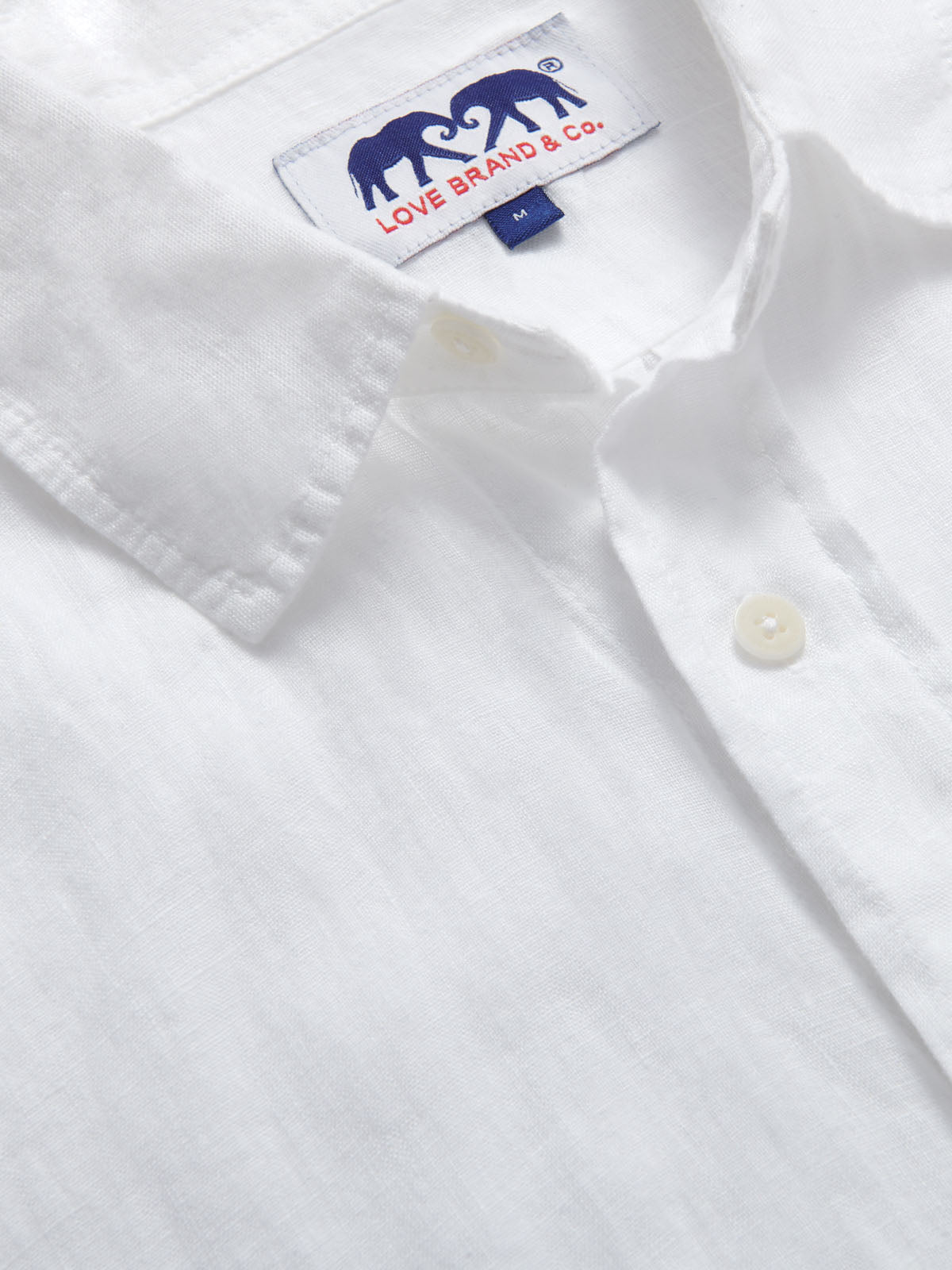 Close-up view of Abaco Mens White Linen Shirt. Detailed view of the label of this mens linen shirt.