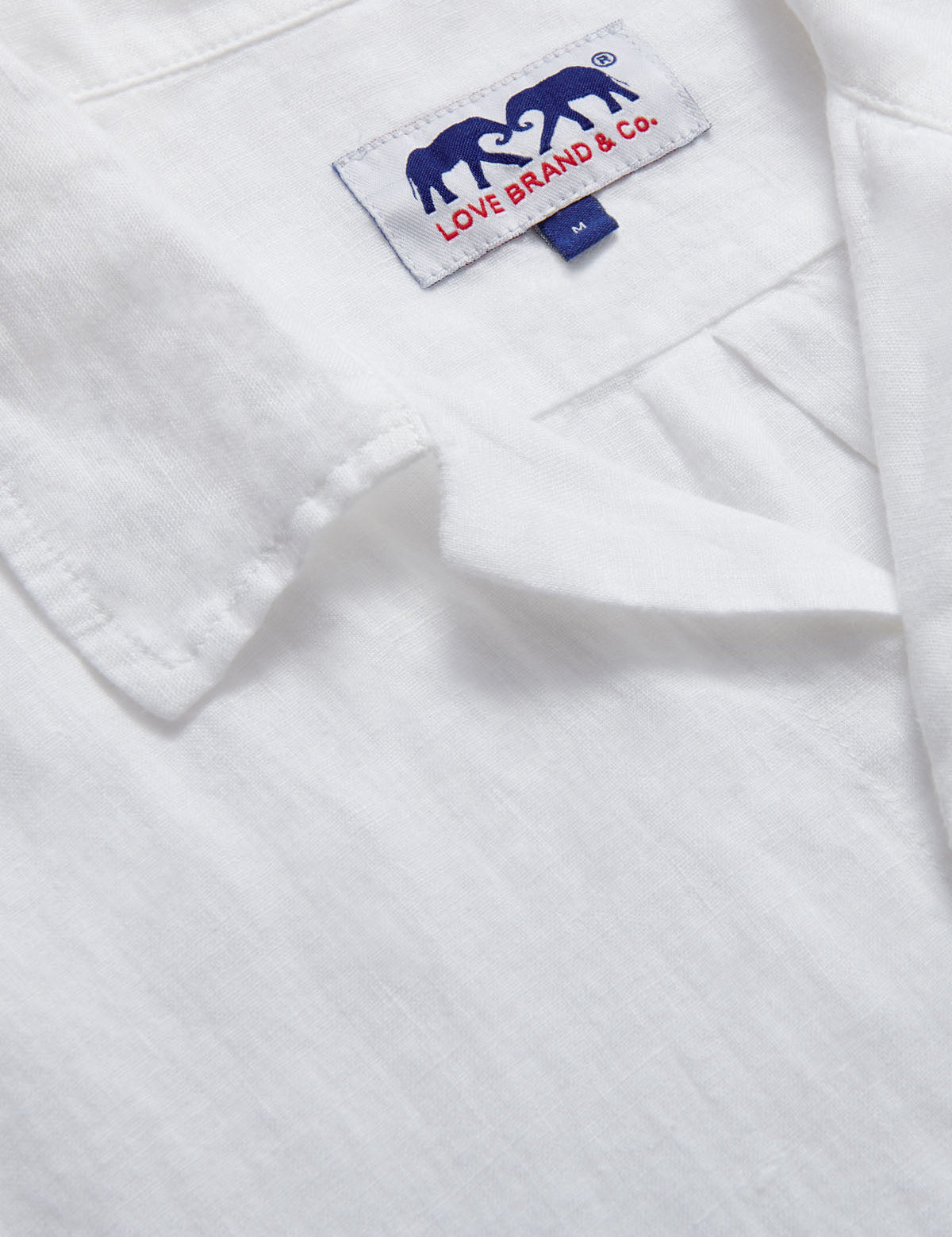 close-up view of Arawak Mens White Linen Shirt showing love brand logo label.