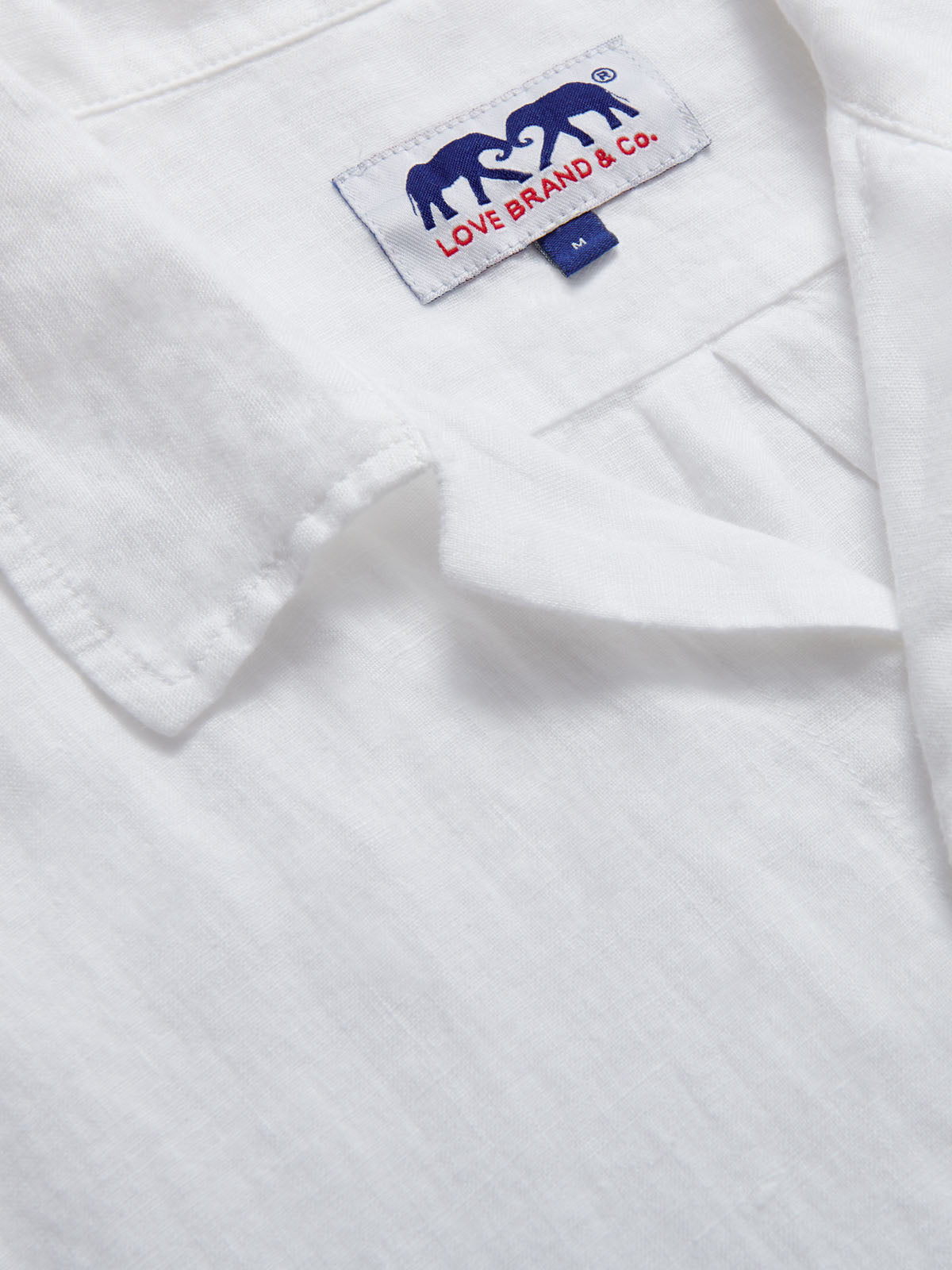 close-up view of Arawak Mens White Linen Shirt showing love brand logo label.