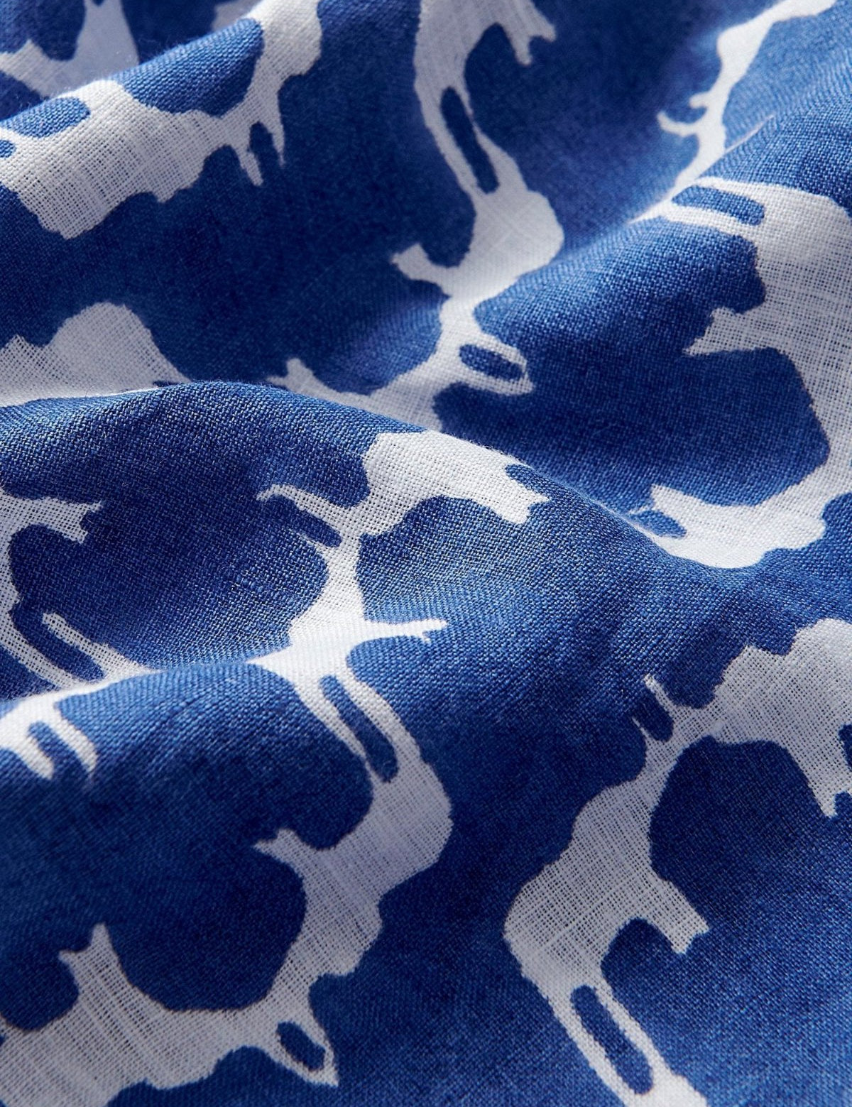 Close-up of blue linen fabric with a white block print pattern. Blue linen pants mens depicting Asian elephants, creating an illusion of Indian palaces.