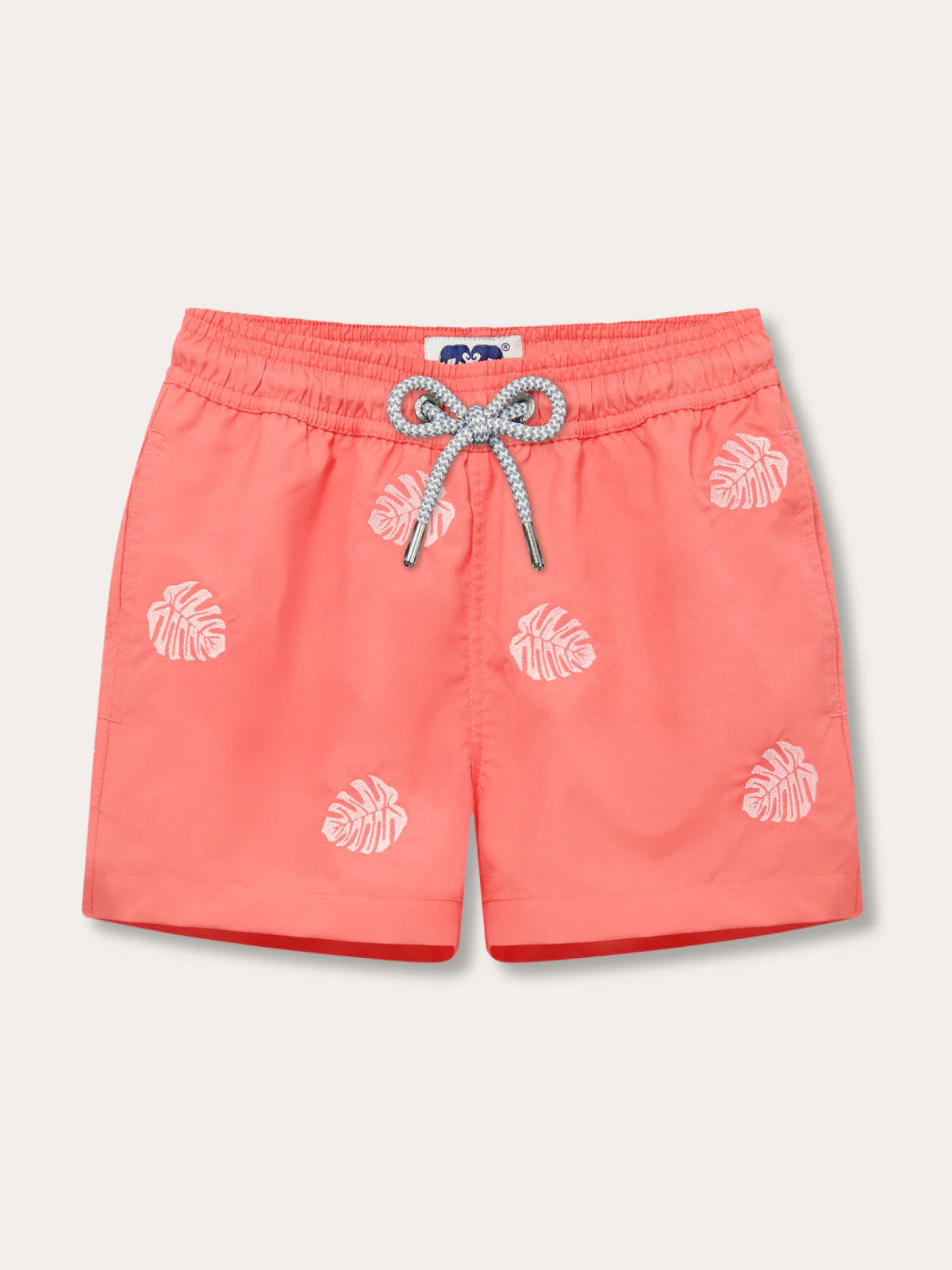 Boys Deliciosa Embroidered Staniel Swim Shorts featuring a Coral Rose base with pink monstera deliciosa leaves.