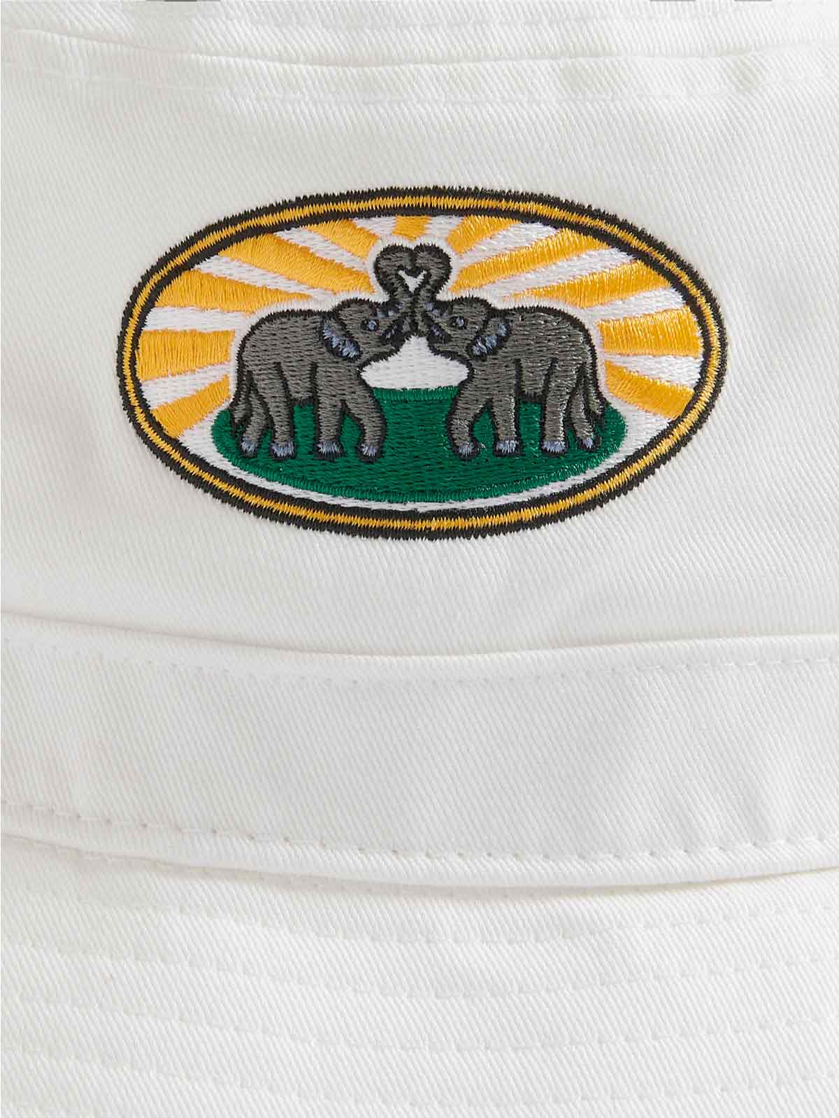 White cotton twill bucket hat with vibrant woven patch of two elephants with intertwined trunks, set against a background of sun rays and greenery.