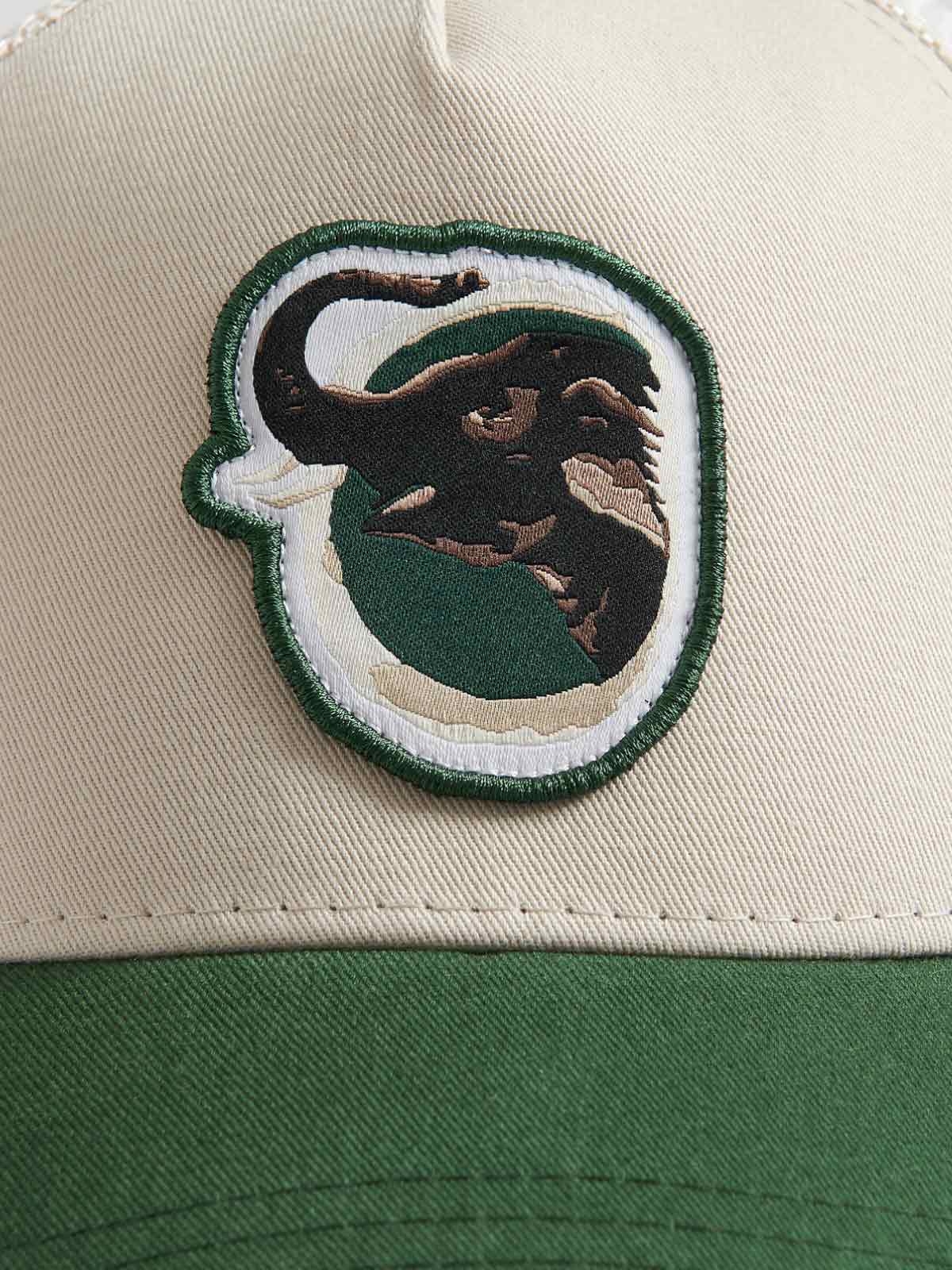 Close-up view of the front panel of the "Trucker Cap - Asian Elephant Trunk Up" featuring a detailed Indian Truck art design of an Asian elephant on a stone cotton twill crown with a forest green visor.