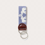 Needlepoint keyring featuring Asian elephants with trunks up forming the illusion of Indian palaces, crafted with blue needlepoint and finished with genuine leather and a brass clasp.