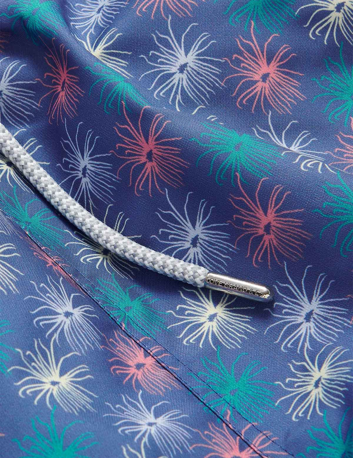 Close-up view of Men's Dont be Anemone Staniel Swim Shorts featuring colorful sea anemone print and braided drawstring.