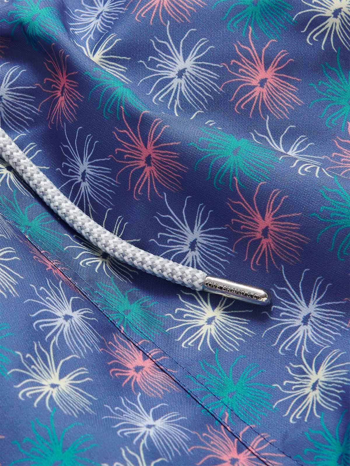 Close-up view of Men's Dont be Anemone Staniel Swim Shorts. Patterned swim shorts featuring colorful sea anemone print and braided drawstring.