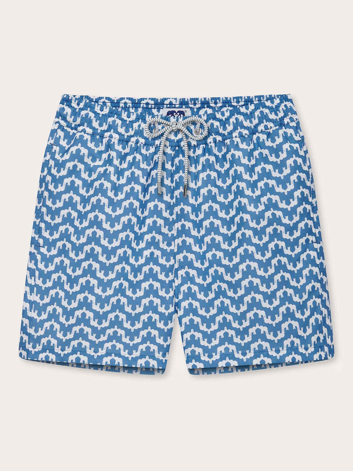 Elephant Palace Blue Staniel mens swim shorts front. Patterned swim shorts featuring white elephants raising their trunks to create a pattern that resembles Indian palaces on a blue background.