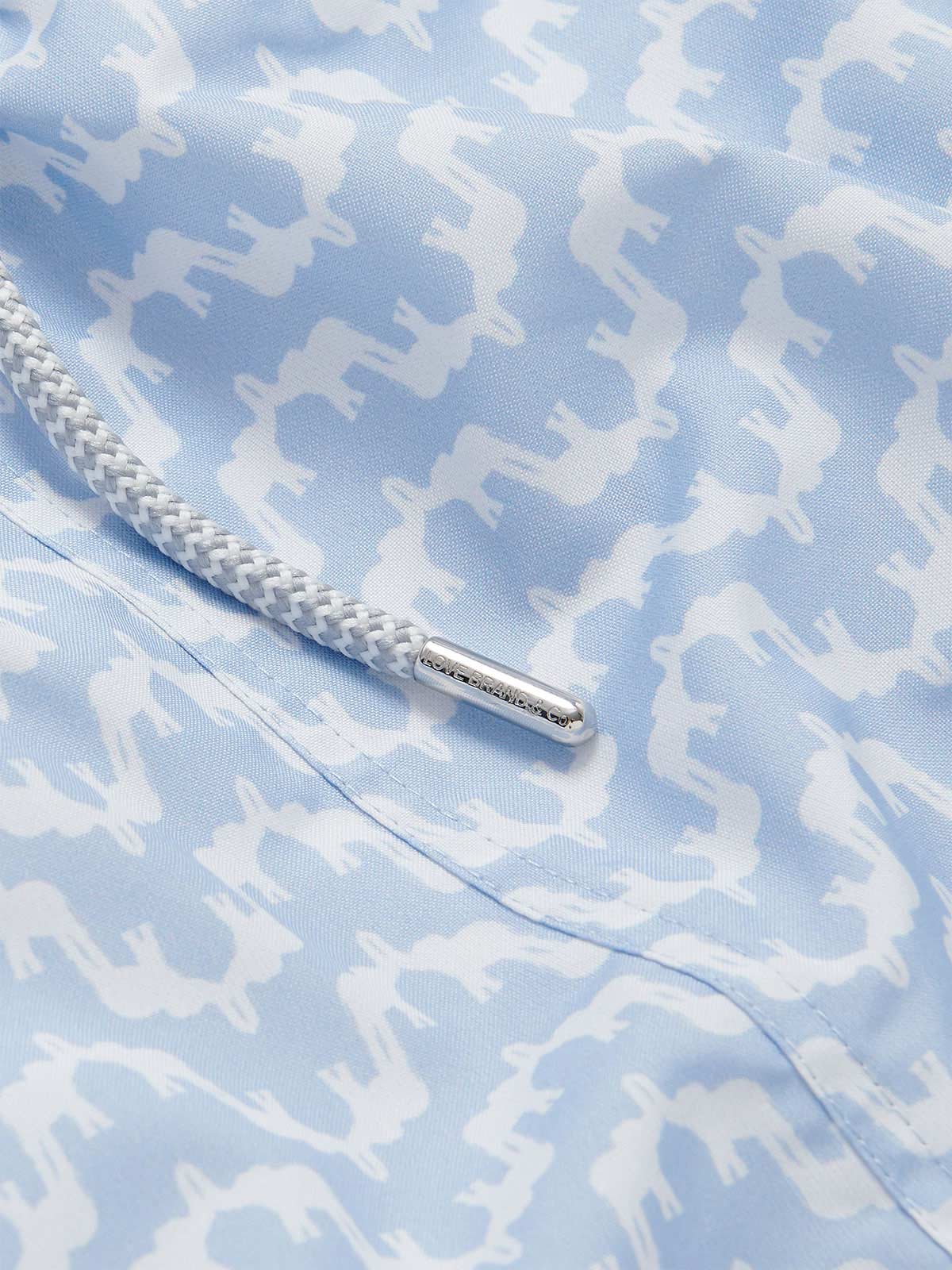 Elephant Palace Sky Staniel mens Swim Shorts details. This design features white elephants raising their trunks to create a pattern that resembles Indian palaces on a sky blue background.