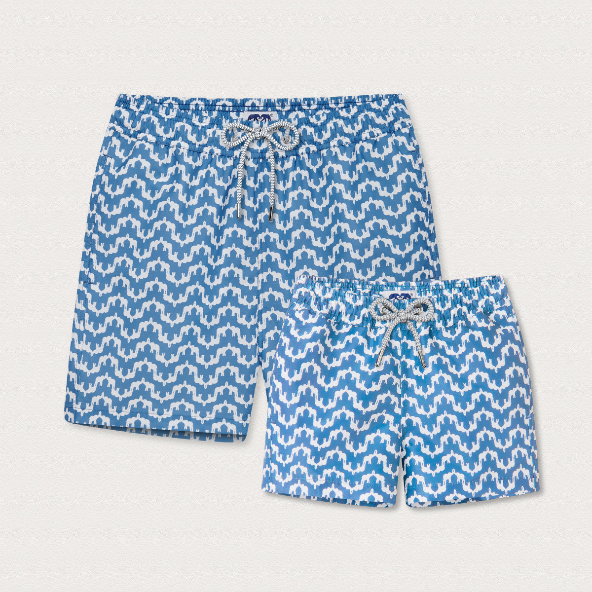 Two pairs of blue swim shorts with a geometric elephant pattern
