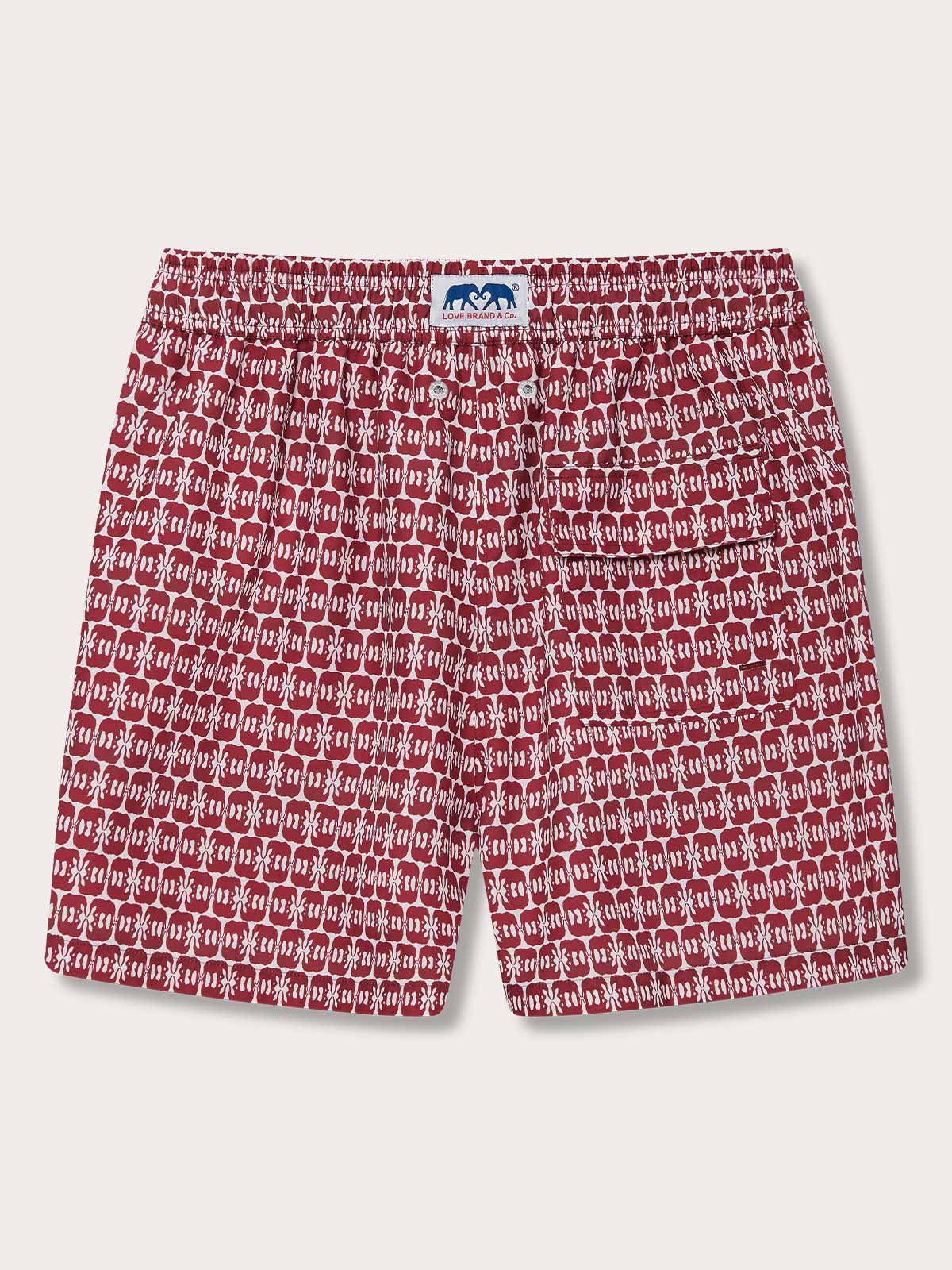 Men's Elephants of India Staniel Swim Shorts featuring dark burgundy elephants print on a crisp white background. Patterned swim shorts made from 100% recycled, quick-drying fabric.