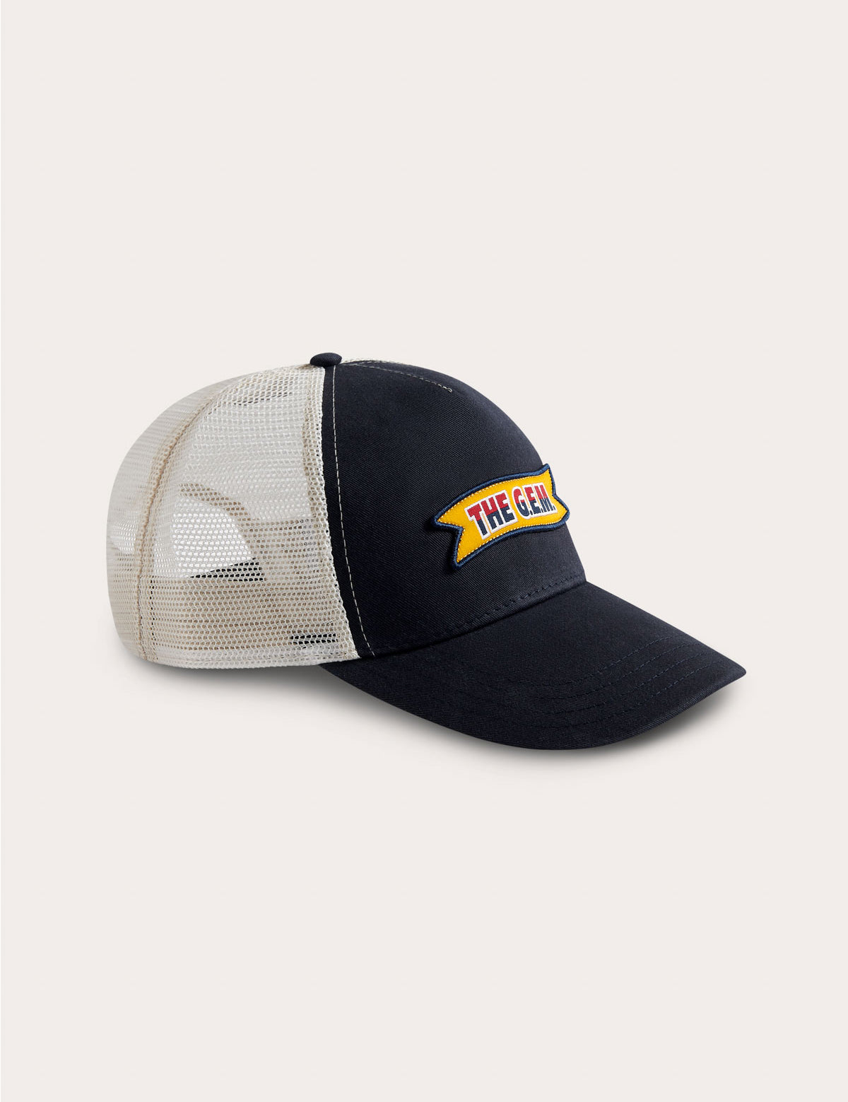 Adjustable navy and stone trucker cap featuring the G.E.M. Ribbon logo label with a merrowed edge on a navy cotton twill crown and visor, and contrast stone trucker mesh.